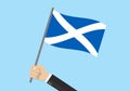 Scotland waving flag. Hand holding Scottish flag. National symbol. Vector illustration